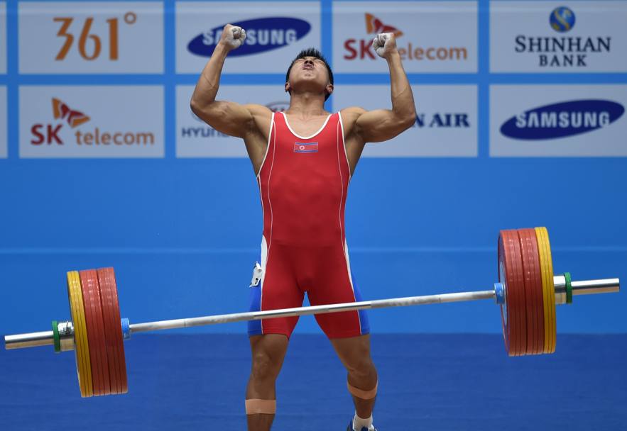 Il nordcoreano Kim Myong-Hyok, categoria 69 kg, esulta dopo un sollevamento riuscito ai Giochi Asiatici di Incheon (Afp)